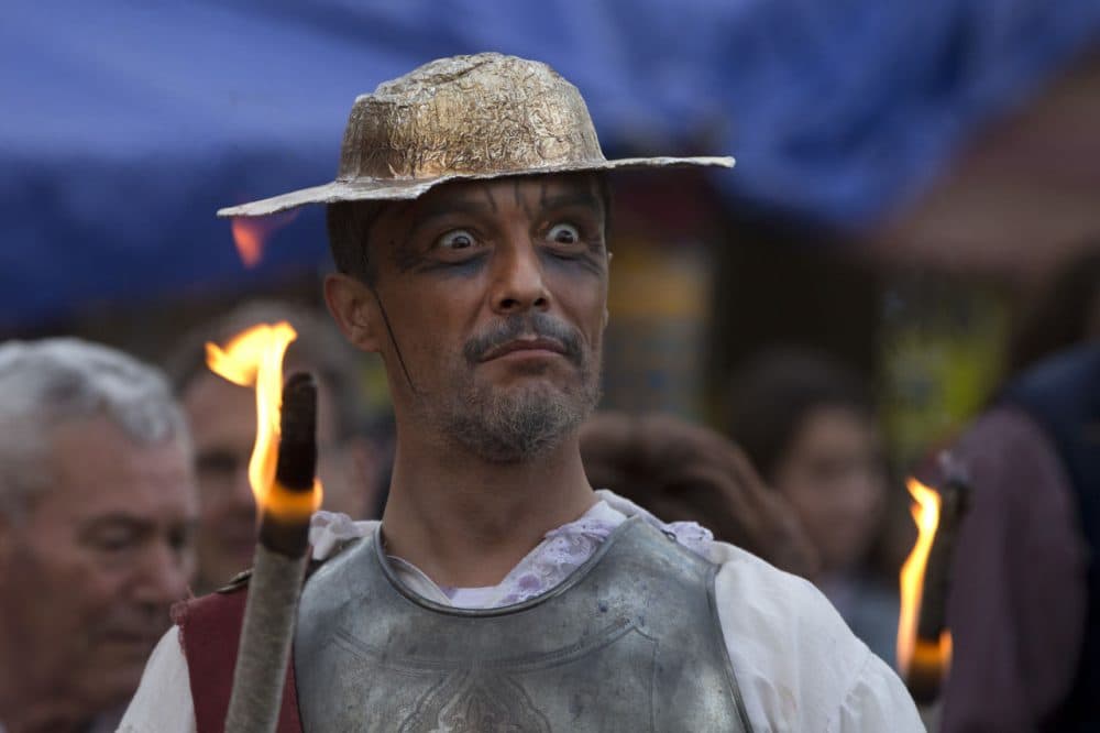 A man dressed as the character of Don Quixote holds a flaming stick during a mock funeral for Spanish writer Miguel de Cervantes, author of 'Don Quixote' to commemorate the 400th anniversary of his death, in his birthplace of Alcala de Henares, Spain, Friday April 22, 2016. (AP Photo/Paul White)