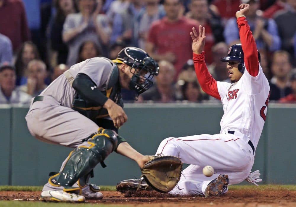 Mookie Betts slides into home for one of the Sox' 13 runs in last night's victory over the A's. (Charles Krupa/AP)