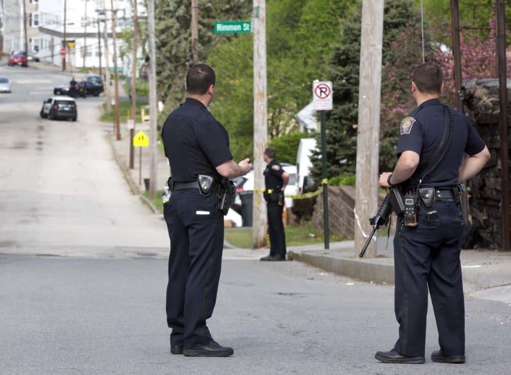Police stand guard during the search for a suspect who shot two police officers early Friday in Manchester, N.H. (Jim Cole/AP)