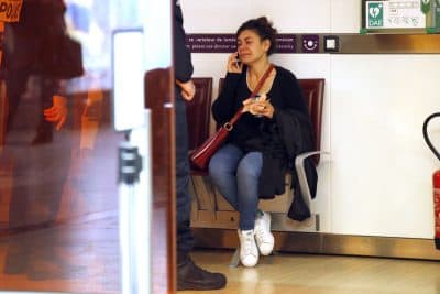 A relative of the victims of the EgyptAir flight 804 that crashed, reacts as she makes a phone call at Charles de Gaulle Airport outside of Paris, Thursday, May 19, 2016. Egyptian aviation officials say an EgyptAir flight from Paris to Cairo with 66 passengers and crew on board has crashed. (AP Photo/Michel Euler)