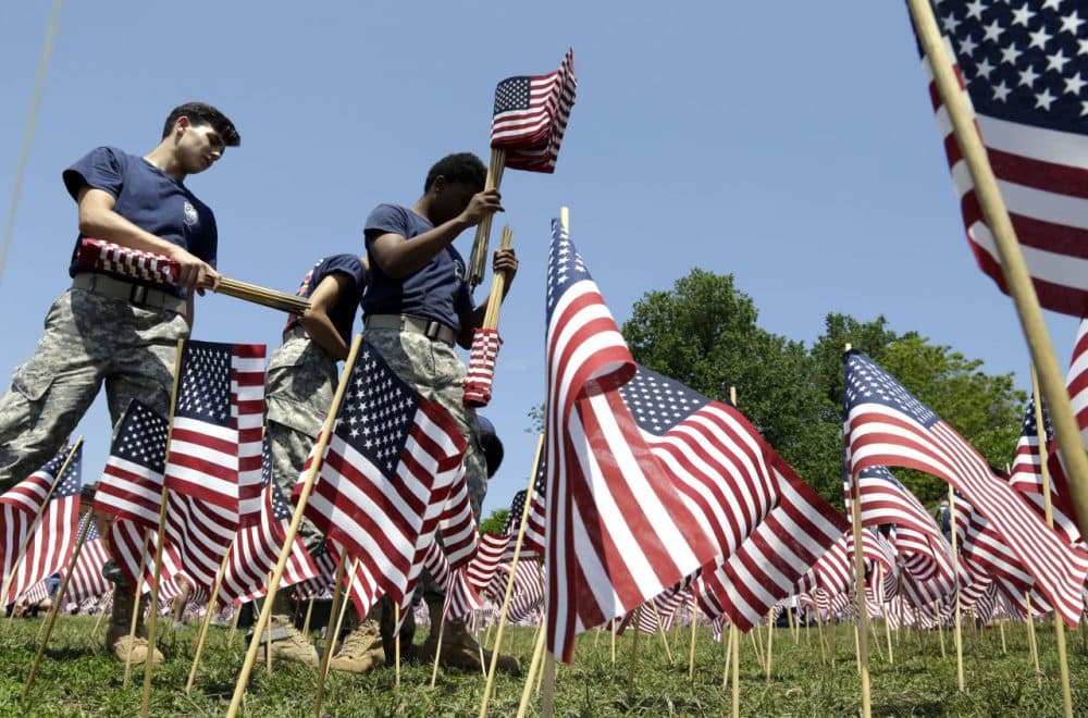Junior ROTC members from Revere High School help to plant flags on the Boston Common. Some 37,000 flags honoring the fallen members of the military from Massachusetts since the Revolutionary War will be placed for Memorial Day weekend. (Elise Amendola/AP)