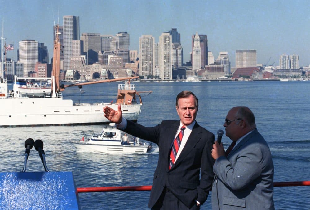 Vice President George H.W. Bush gestures from a boat in Boston Harbor during a campaign stop in Boston, where he attacked Massachusetts Gov. Michael Dukakis on his environmental record involving the harbor in September 1988. (J. Scott Applewhite/AP)