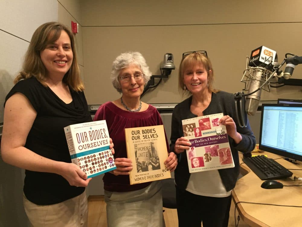 Our Bodies Ourselves executive director Julie Childers (left) and co-founder Judy Norsigian (middle) stand with Here &amp; Now co-host Robin Young in the Here &amp; Now studios. (Eileen Bolinsky/Here &amp; Now)