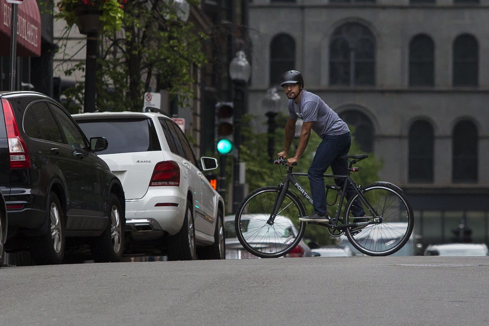 Fortified Bicycle president Tivan Amour rides on Boston's Avenue de Lafayette. (Jesse Costa/WBUR)