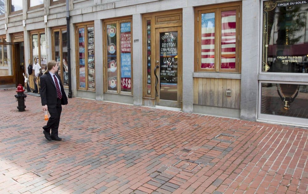 A passerby notices artist Pat Falco's faux Boston Campaign Headquarters meant to poke fun at election season. (Joe Difazio for WBUR)