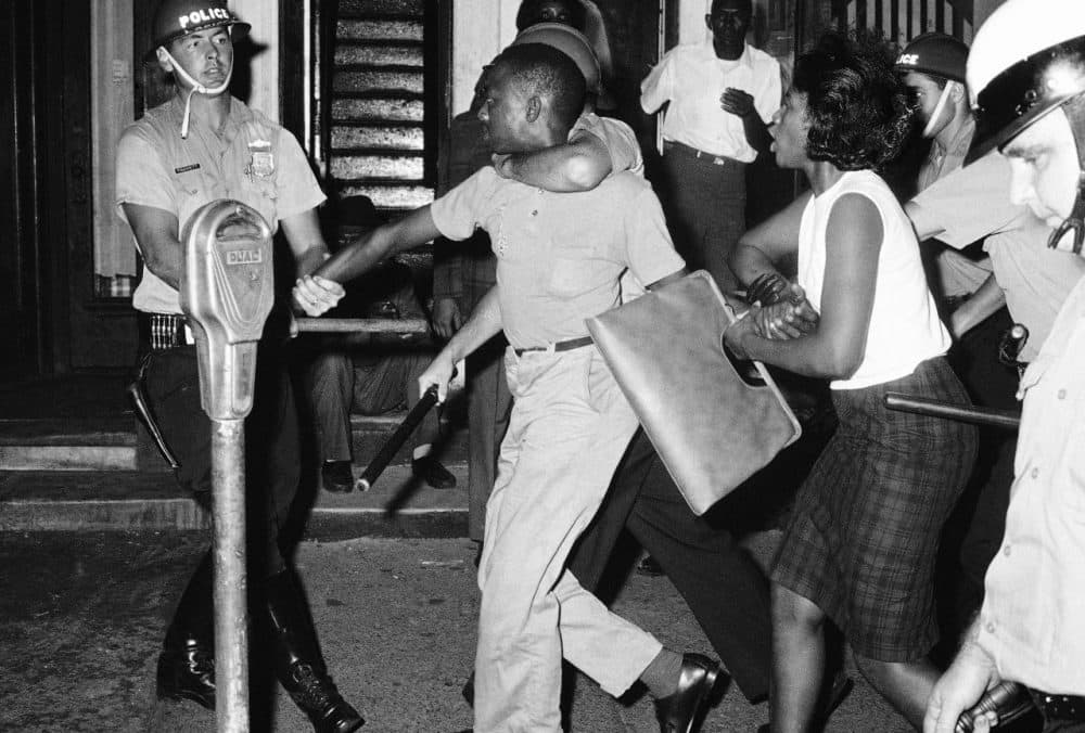 Steel-helmeted police pull a demonstrator toward police van as they arrest him during rioting in Philadelphia's North Side, August 1964. (AP)
