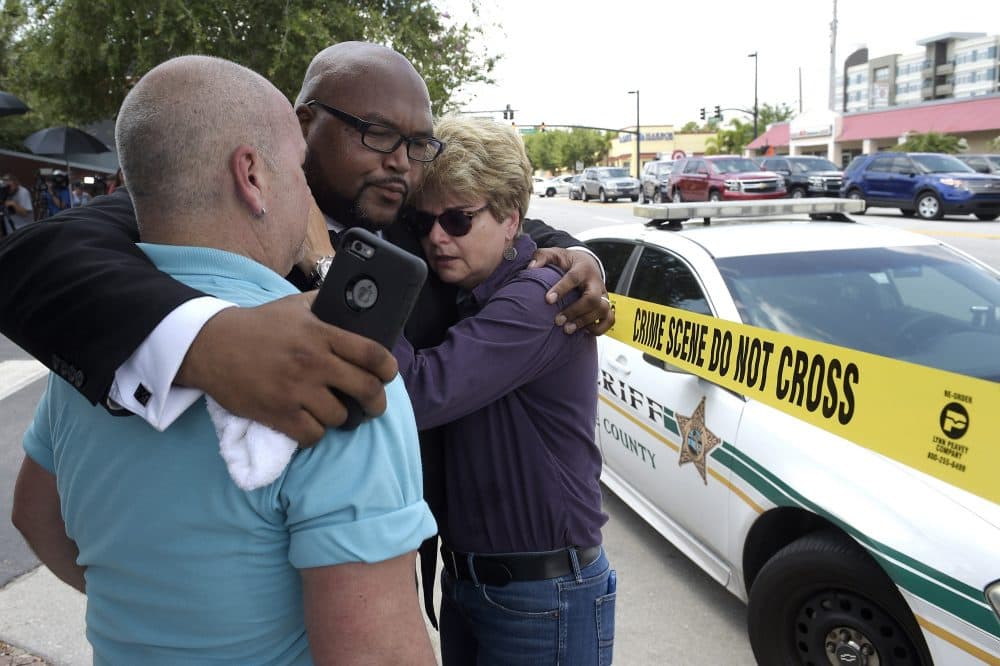 Terry DeCarlo, executive director of the LGBT Center of Central Florida, left, Kelvin Cobaris, pastor of The Impact Church, center, and Orlando City Commissioner Patty Sheehan console each other. (Phelan M. Ebenhack/AP)