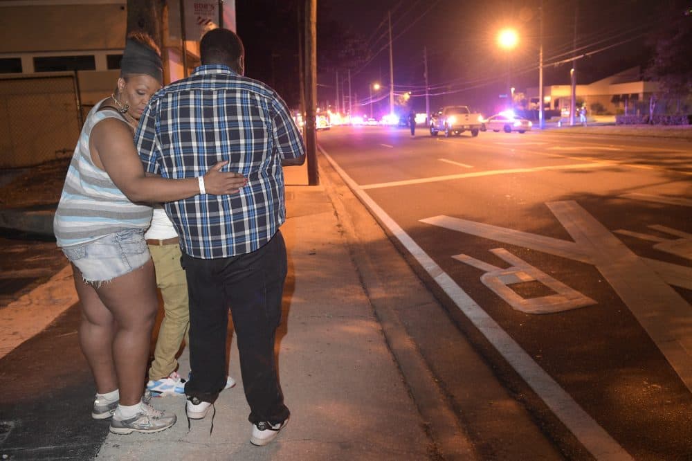 Bystanders wait down the street from the site of the shooting. (Phelan M. Ebenhack/AP)