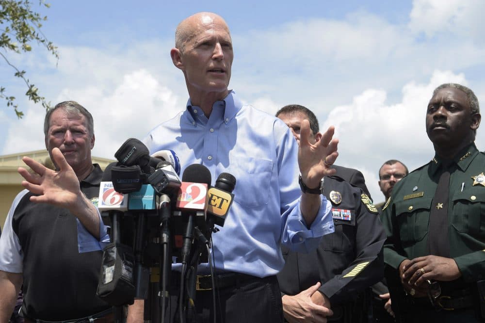 Florida Gov. Rick Scott, center, addresses reporters during a news conference after the shooting. (Phelan M. Ebenhack/AP)