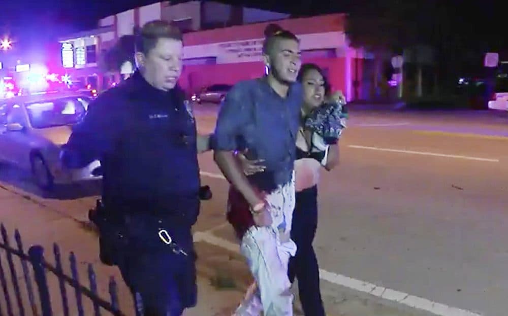 An injured man is escorted out of the Pulse nightclub after the shooting rampage. (Steven Fernandez/AP)