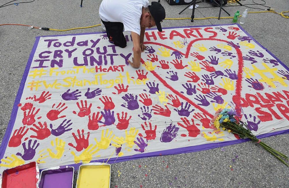 A man places a hand print on a makeshift memorial in a parking lot near the Pulse nightclub in Orlando, Florida on June 12, 2016.
(Mandel Ngan /AFP/Getty Images)