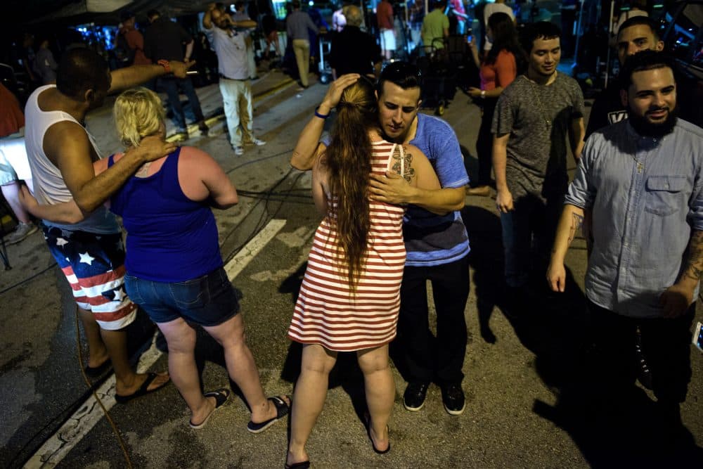 People hug after praying near the Pulse nightclub on June 12, 2016 in Orlando, Florida. (BRENDAN SMIALOWSKI/AFP/Getty Images)