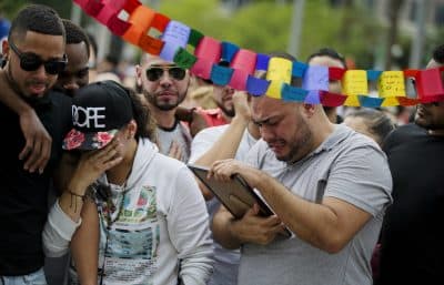 Jose Hernandez, right, cries as he looks at a photo of his friend Amanda Alvear, who was killed in the mass shooting at the Pulse nightclub, as he visits a makeshift memorial with friends, Monday, June 13, 2016, in Orlando, Fla. (David Goldman/AP)