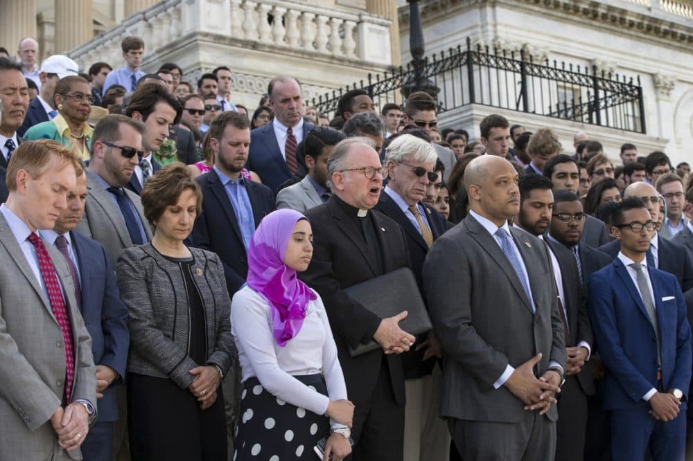 Members of Congress join the LGBT Congressional Staff Association and the Congressional Muslim Staff Association for a prayer and moment of silence on the steps of the Capitol to stand in solidarity with the Orlando community and to remember the victims of Sunday’s shooting at an LGBT night club, in Washington, Monday, June 13, 2016. Father Patrick J. Conroy, center, chaplain of the House of Representatives, delivered an interfaith message. (J. Scott Applewhite/AP)