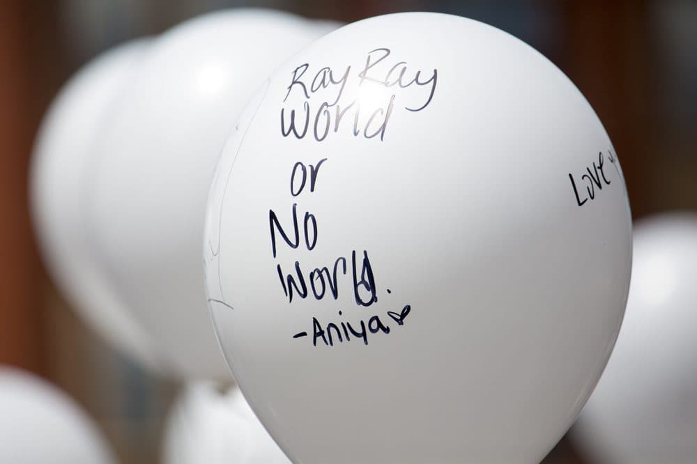 Mourners wrote personal messages on white balloons, which were given out to Burke High School students to release into the air at the burial site. (Jesse Costa/ WBUR)