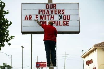 Jiffy Lube employee Ralph Nieves put up a sign of support for the Orlando community following the shooting at the Pulse nightclub last Saturday night on June 16, 2016 in Orlando, Florida. (Spencer Platt/Getty Images)