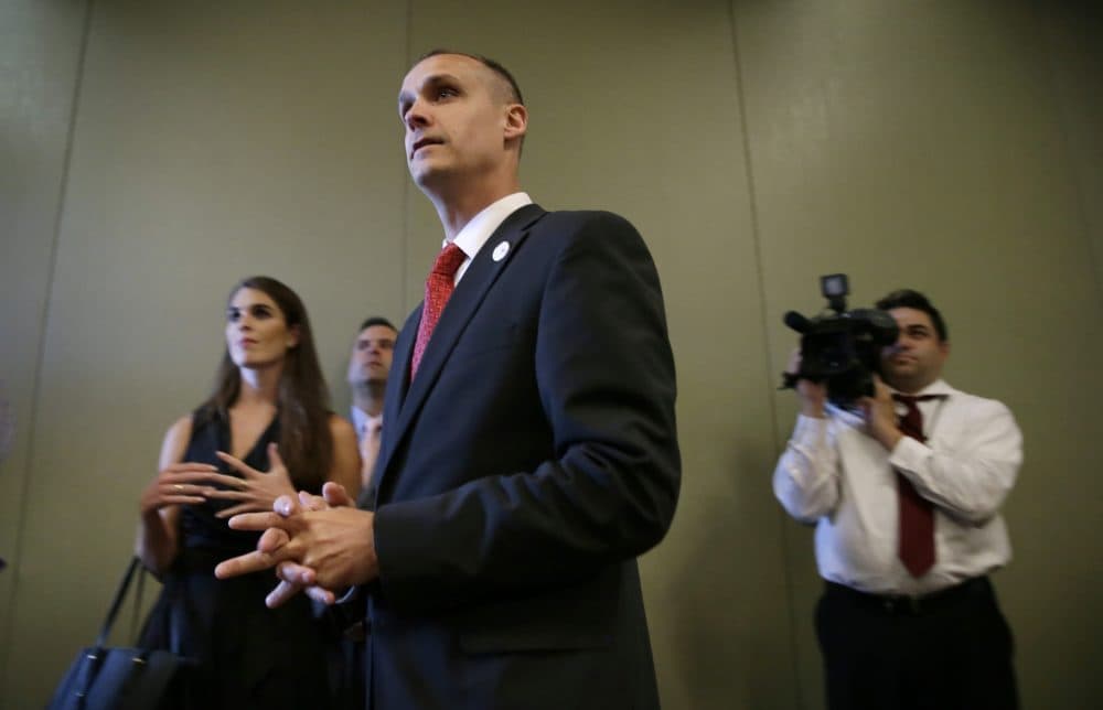 In this photo taken Aug. 25, 2015, Republican presidential candidate Donald Trump's campaign manager Corey Lewandowski watches as Trump speaks in Dubuque, Iowa. Florida police have charged Lewandowski with simple battery in connection with an incident earlier in the month involving a reporter. (Charlie Neibergall/AP)