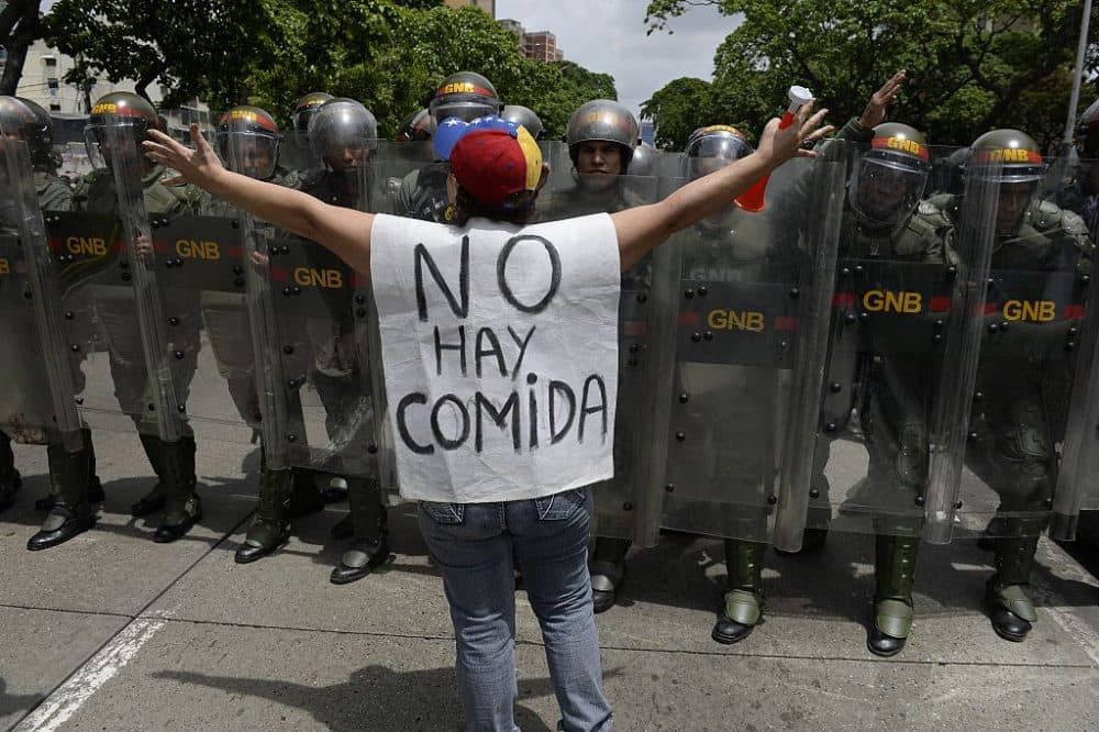 A woman with a sign reading &quot;There is no food&quot; protests against new emergency powers decreed this week by President Nicolas Maduro in front of a line of policemen in Caracas on May 18, 2016. (Federico Parra /AFP/Getty Images)