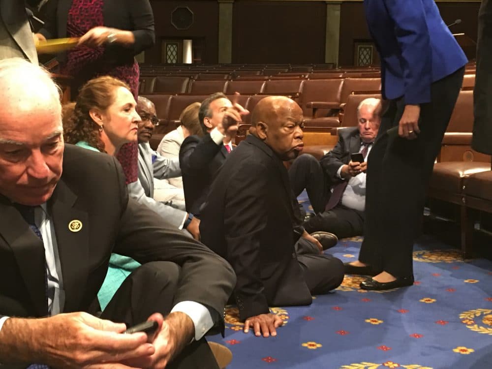 This photo provided by Rep. John Yarmuth, D-Ky., shows Democrat members of Congress, including Rep. John Lewis, D-Ga., center, and Rep. Joe Courtney, D-Conn., left, participate in sit-down protest seeking a a vote on gun control measures, Wednesday, June 22, 2016, on the floor of the House on Capitol Hill in Washington. (Rep. John Yarmuth/AP)