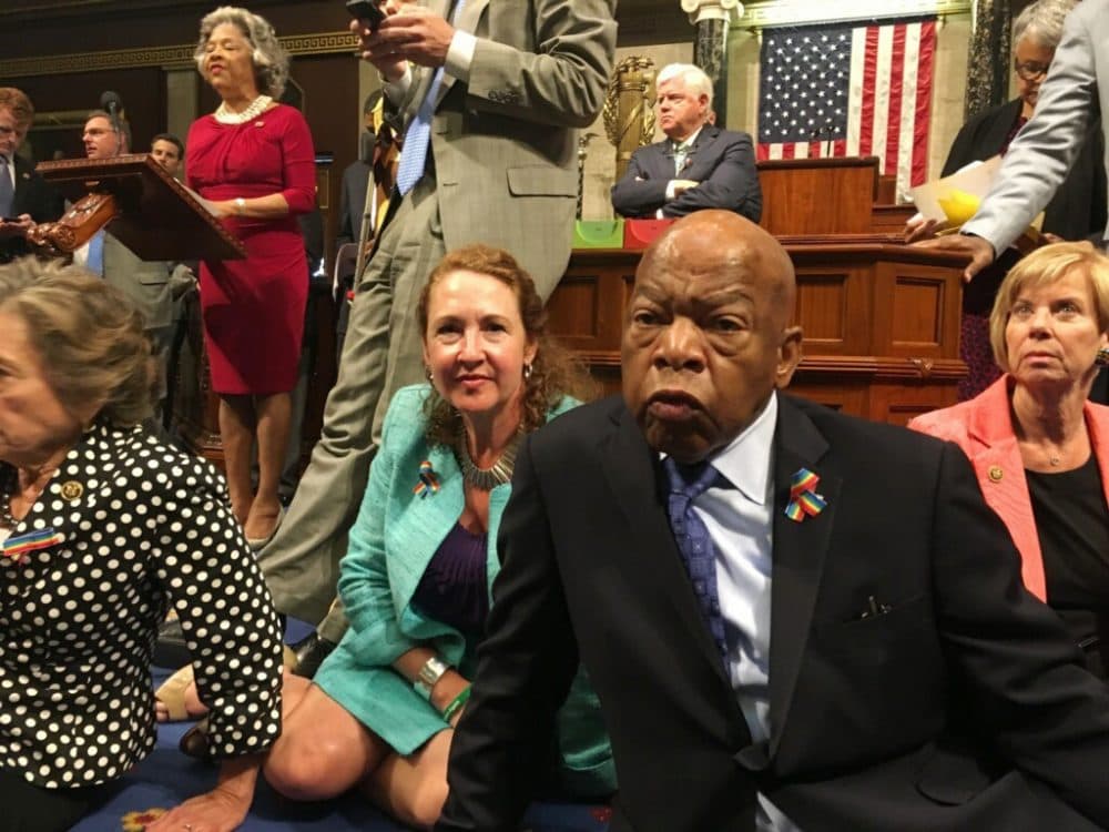This photo provided by Rep. Chillie Pingree, D-Maine, shows Democrat members of Congress, including Rep. John Lewis, D-Ga., center, and Rep. Elizabeth Esty, D-Conn. as they participate in sit-down protest seeking a a vote on gun control measures, Wednesday, June 22, 2016, on the floor of the House on Capitol Hill in Washington.  (Rep. Chillie Pingree via AP)