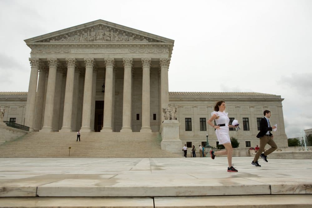 Interns race to deliver hard copies of a Supreme Court decision regarding Obama's immigration plan to waiting news crews at the U.S. Supreme Court, on June 23, 2016 in Washington, DC.  The court was divided 4-4, leaving in place an appeals court ruling blocking the plan, which would have protected millions of immigrants from deportation. (Allison Shelley/Getty Images)