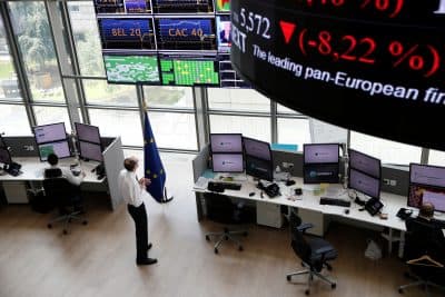 People work as screens display news and trading rates at the Euronext Stock Exchange services in Paris' financial district of La Defense on June 24, 2016 as Britain votes to leave the European Union, fuelling a wave of global uncertainty. (Thomas Samsom/AFP/Getty Images)