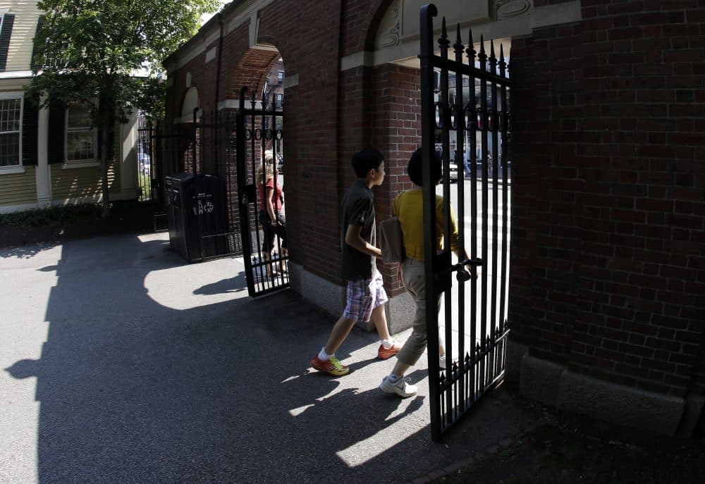 Pedestrians walk through a gate on Harvard University's campus. (Elise Amendola/AP)