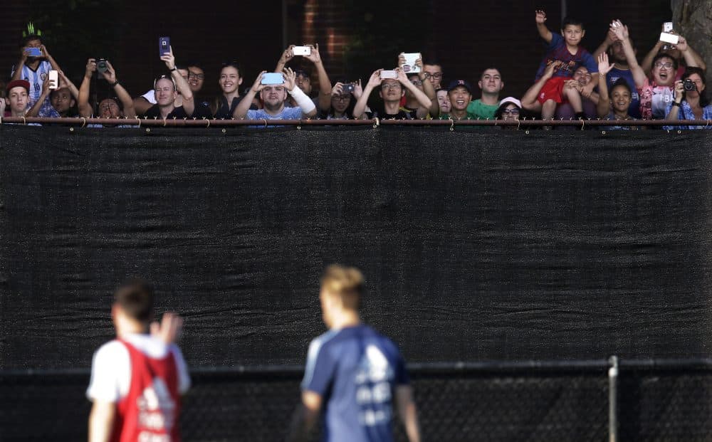 Argentina's Lionel Messi, left, waves to fans after a practice Thursday at Harvard University. (Charles Krupa/AP)