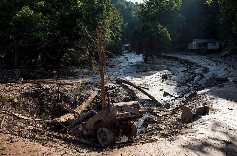 A truck lies in a hole amongst the mud after it was washed out of the driveway from the flooding on June 25, 2016 in Clendenin, West Virginia. The flooding of the Elk River claimed the lives of 26 people in West Virginia. (Ty Wright/Getty Images)