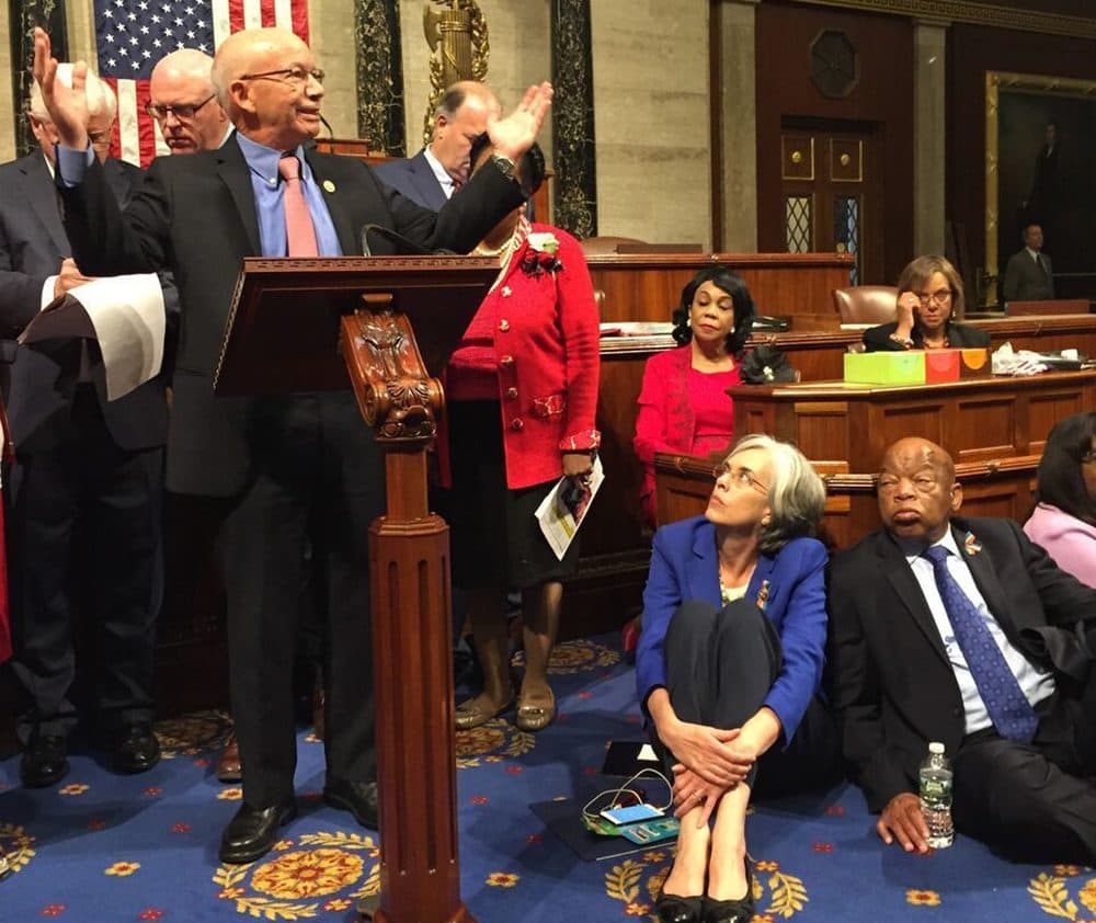 This photo provided by Rep. Suzanne Bonamici, D-Ore., shows Democrats including Massachusetts Rep. Katherine Clark, seated, in blue, participating in a sit-in protest seeking a a vote on gun control measures, Wednesday on the floor of the House on Capitol Hill in Washington. (Rep. Suzanne Bonamici via AP)