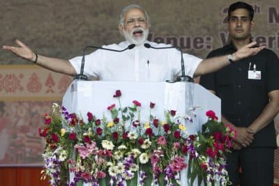 Indian prime minister Narendra Modi, left, addresses supporters in Gauhati, India, Tuesday, May 24, 2016. (AP Photo/ Anupam Nath)