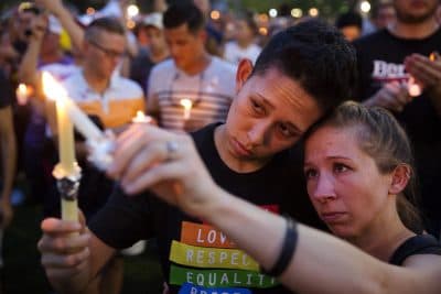 In this Monday, June 13, 2016 file photo, Jennifer, right, and Mary Ware light candles during a vigil in Orlando, Fla., for the victims of the mass shooting at the Pulse nightclub. (David Goldman / AP)