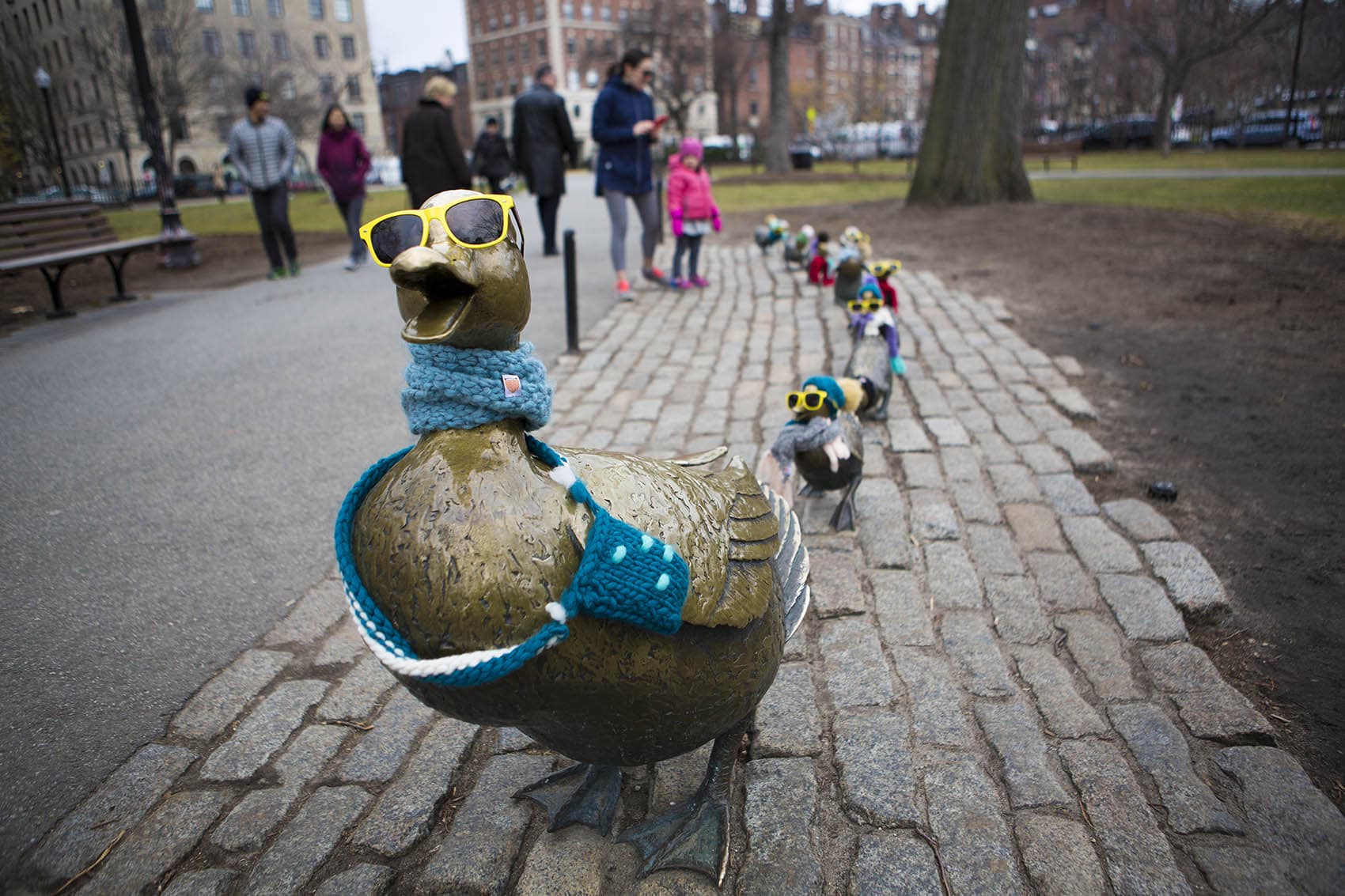Nancy Schon's Make Way For Ducklings Statues dreassed in winter clothing in The Public Gardens. (Jesse Costa/WBUR)