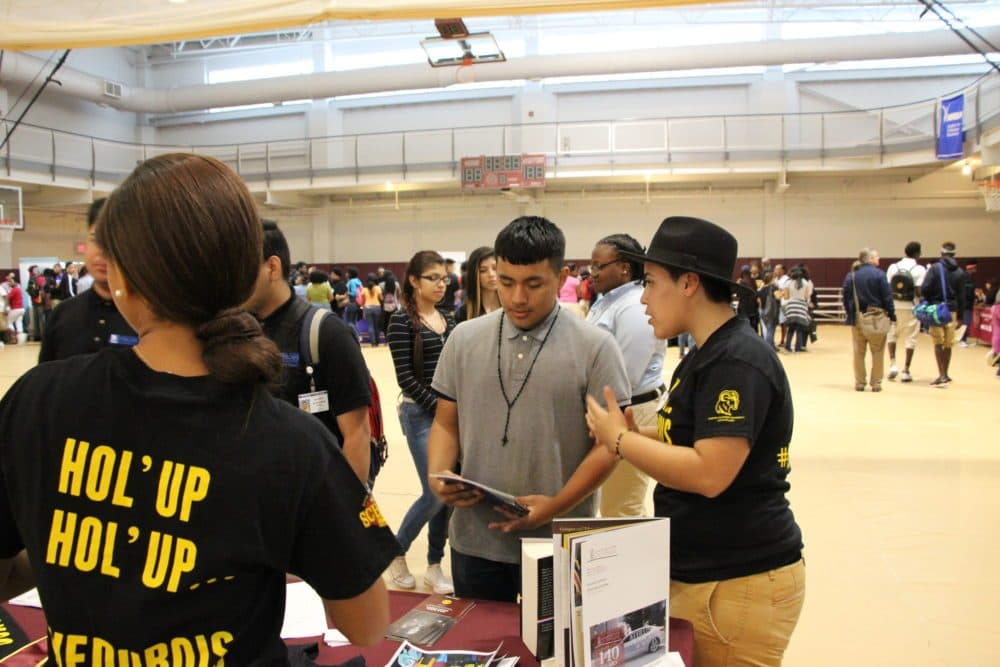 Huston-Tillotson graduate Angelica Erazo, 22, gave her pitch about the benefits of historically black colleges and universities to Luis Betancourt, 15, a high school freshman already thinking about college. The Houston Independent School District held an HBCU college summit at Texas Southern University in May. (Laura Isensee/Houston Public Media)