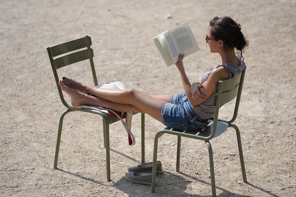 A woman reads a book under the sun in the Luxembourg gardens in Paris, on July 1, 2010. (Miguel Median/AFP/Getty Images)