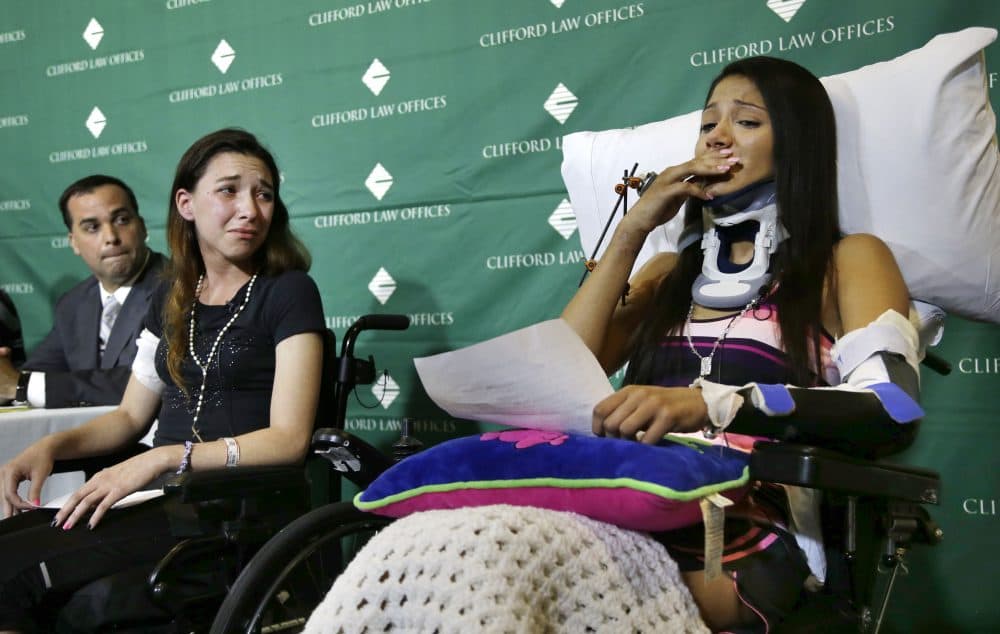 Circus acrobats Julissa Segrera, second from left, of the United States, and Dayana Costa, right, of Brazil, are tearful as Costa reads a statement to members of the media at Spaulding Rehabilitation Hospital on May 17, 2014. (Steven Senne/AP)