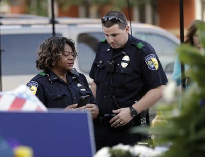 Police officers visit a makeshift memorial at the headquarters of the Dallas Police Department Saturday in Dallas. Five police officers are dead and several injured following a shooting in downtown Dallas Thursday night. (Eric Gay/AP)