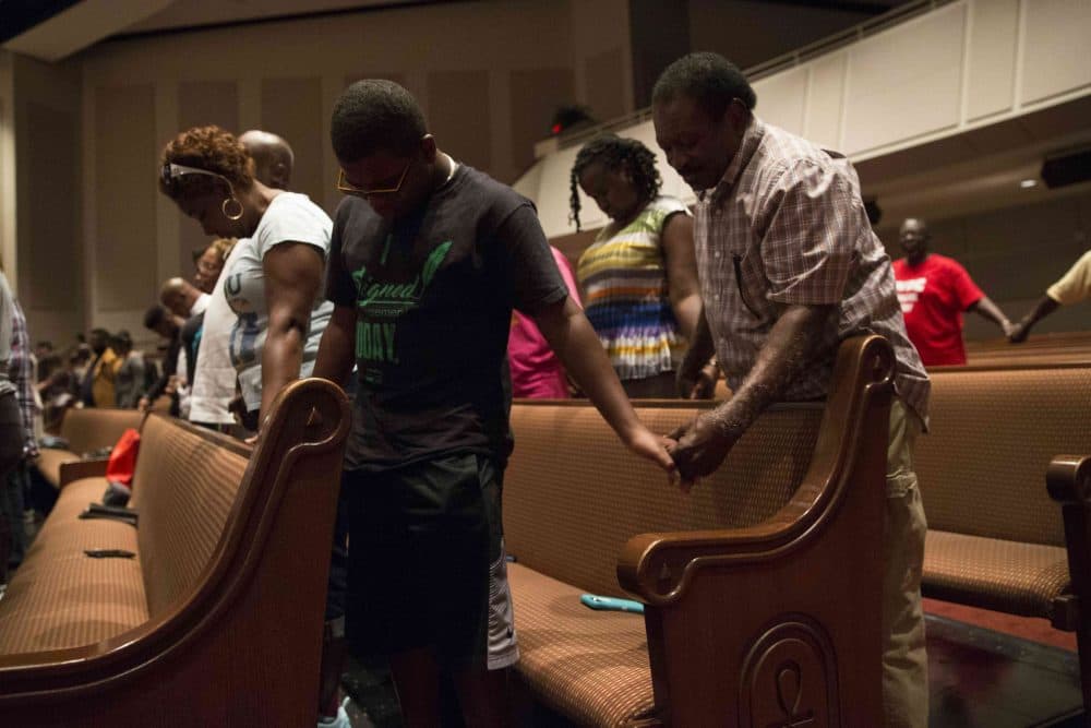 Parishioners of Frienship-West Baptist Church in Dallas, Texas, pray together on July 10, 2016, during a &quot;Community Conversation&quot; event following the recent sniper attacks against white police officers.
The Dallas gunman was plotting a major bomb attack, authorities said, urging calm after more than 200 people were arrested in a new night of protests over police violence against blacks. (Laura Buckman/AFP/Getty Images)