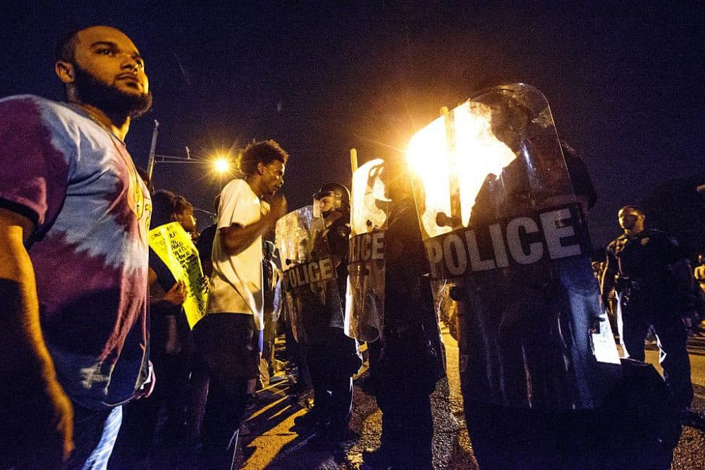 Protesters face off with Baton Rouge police in riot gear across the street from the police department on July 8, 2016 in Baton Rouge, Louisiana. Alton Sterling was shot by a police officer in front of the Triple S Food Mart in Baton Rouge on July 5th, leading the Department of Justice to open a civil rights investigation. (Mark Wallheiser/Getty Images)