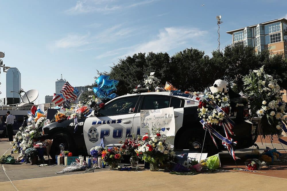 People write condolence notes and lay flowers at a growing memorial in front of the Dallas Police Headquarters near the area that is still an active crime scene in downtown Dallas following the deaths of five police officers on July 8, 2016 in Dallas, Texas. (Spencer Platt/Getty Images)