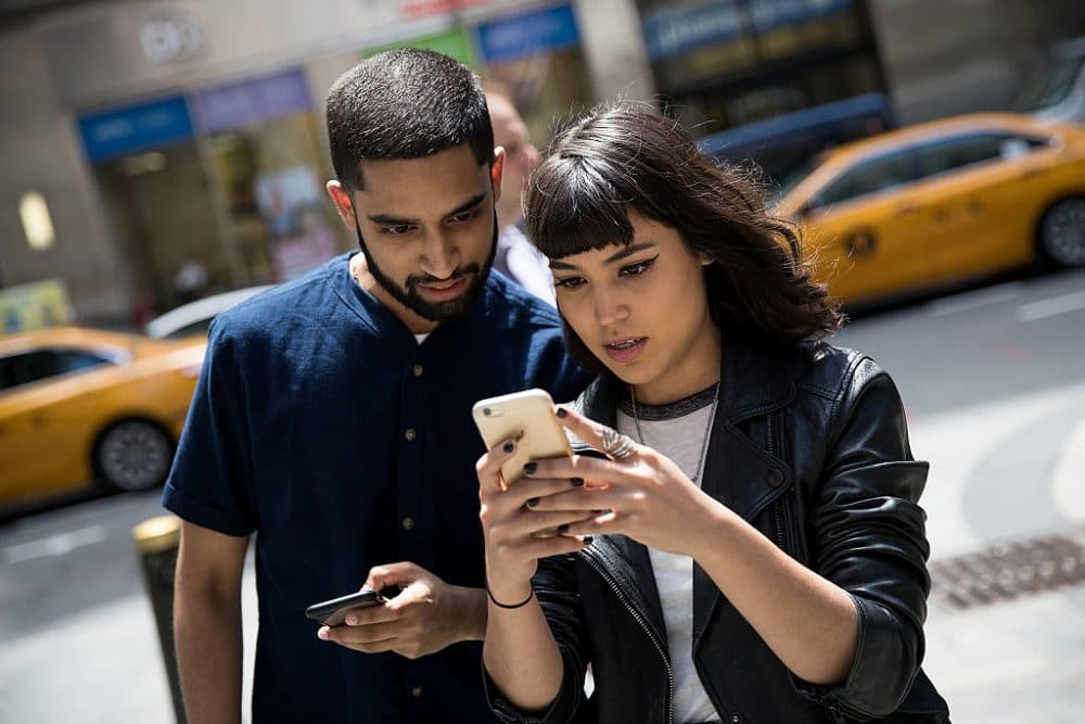 Left to right: Sameer Uddin and Michelle Macias play Pokemon Go on their smartphones outside of Nintendo's flagship store, July 11, 2016 in New York City. The success of Nintendo's new smartphone game, Pokemon Go, has sent shares of Nintendo soaring. (Drew Angerer/Getty Images)