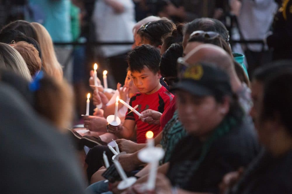 A young boy sitting in the section reserved for family of the police officers killed in Dallas lights a candle during a &quot;Dallas Strong&quot; event on July 11, 2016 in Dallas, Texas. (Laura Buckman/AFP/Getty Images)