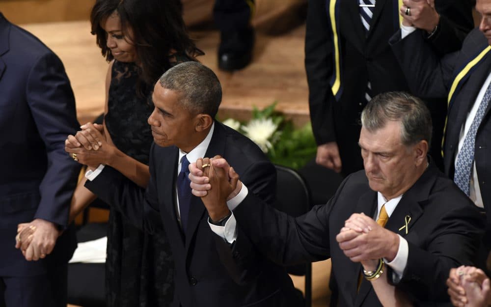 President Barack Obama holds hands with Dallas Mayor Mike Rawlings, right, and first lady Michelle Obama during an interfaith memorial service for the fallen police officers and members of the Dallas community in Dallas Tuesday. (Susan Walsh/AP)