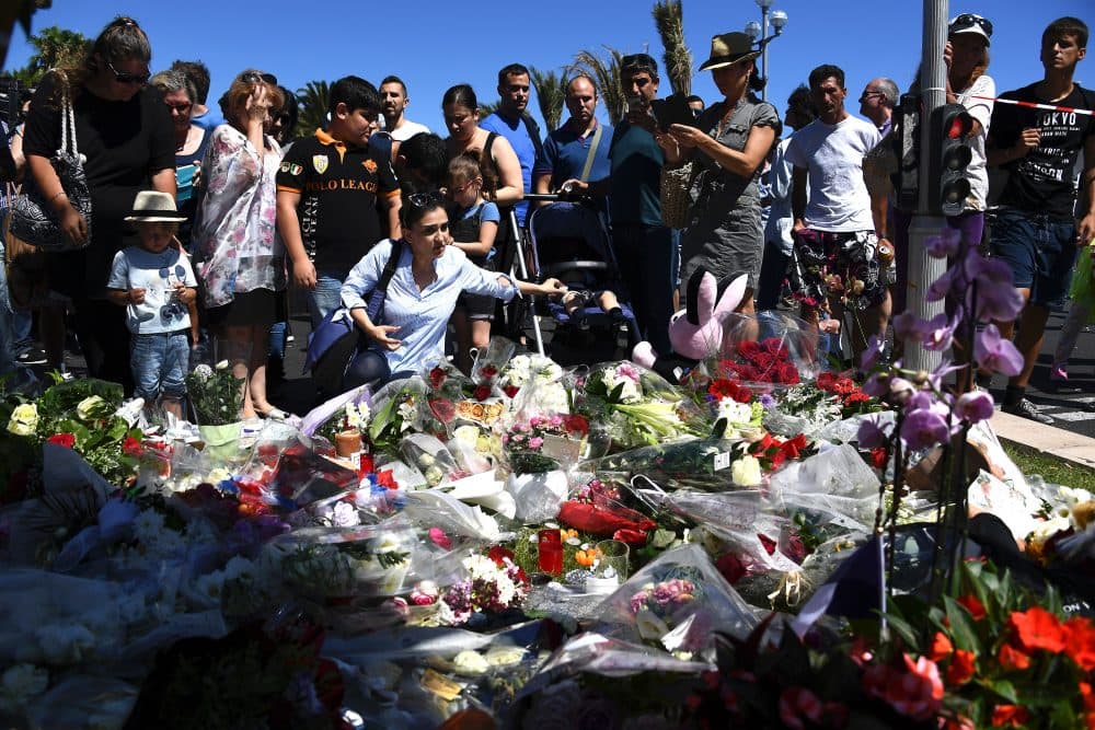 People lay flowers in the street of Nice to pay tribute to the victims the day after a gunman smashed a truck into a crowd of revellers celebrating Bastille Day, killing at least 84 people, on July 15, 2016. (Anne-Christine Poujoulat/AFP/Getty Images)