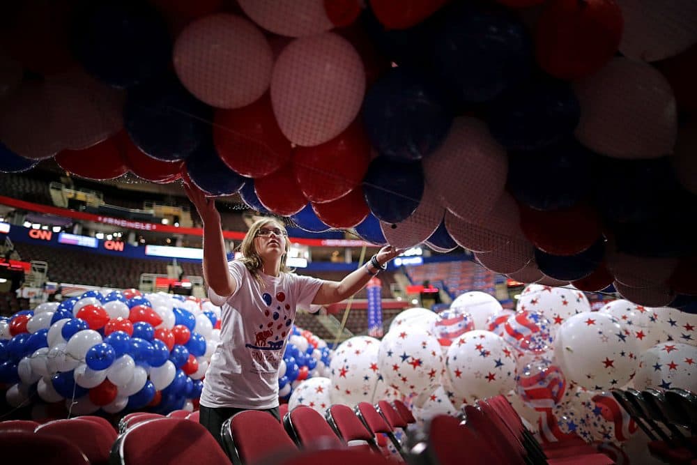Volunteer June Fertiz, 15, with the band and choir group from Garfield Heights High School, helps move nets filled with thousands of red, white and blue balloons before they are lifted into the ceiling of the Quicken Loans Arena July 15, 2016 in Cleveland, Ohio. (Chip Somodevilla/Getty Images)