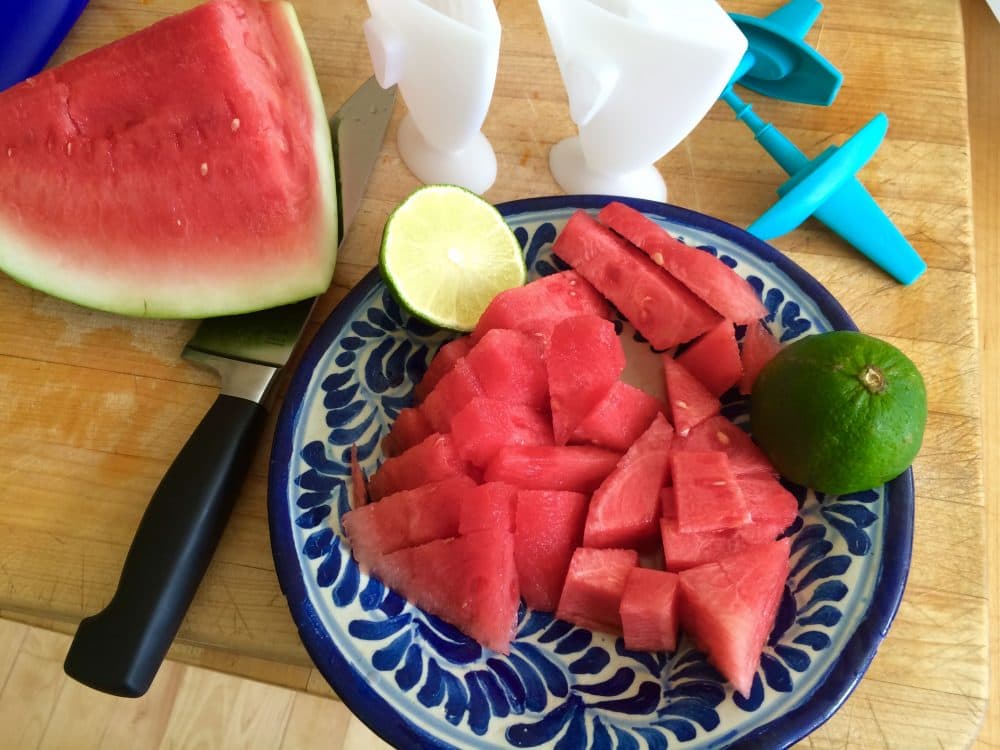 A plate of sliced watermelon and lime, which will be used to make Kathy's watermelon-lime popsicles. (Kathy Gunst for Here & Now)