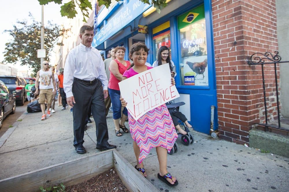 Eight-year-old Natalie Lemus walks with Mayor Marty Walsh down Chelsea Street during a neighborhood walk for peace in East Boston Tuesday night. (Jesse Costa/WBUR)