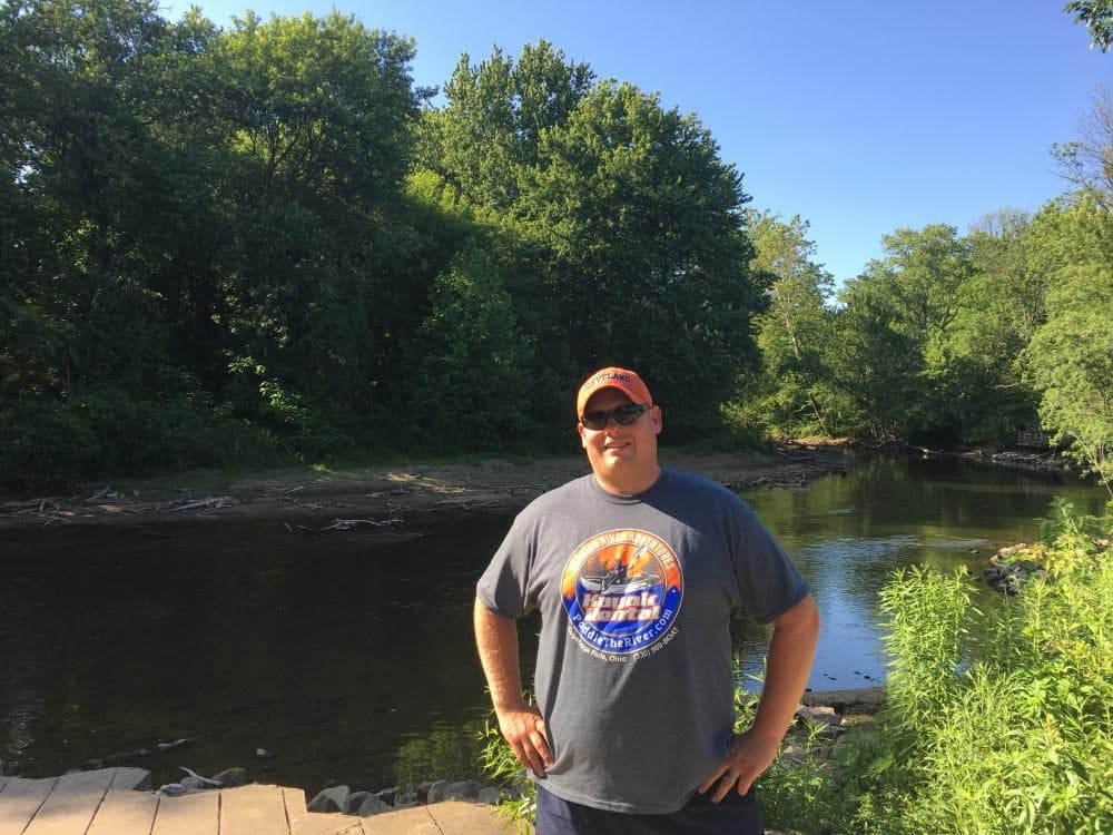Brad McBride, of Burning River Adventures, stands near the banks of the Cuyahoga River. (Elizabeth Miller/WCPN)