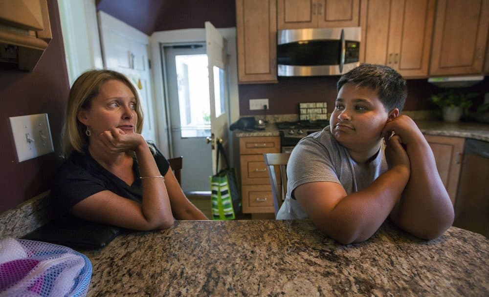Judy Tasker and her adopted transgender son Nathan chat in their kitchen. (Jesse Costa/WBUR)