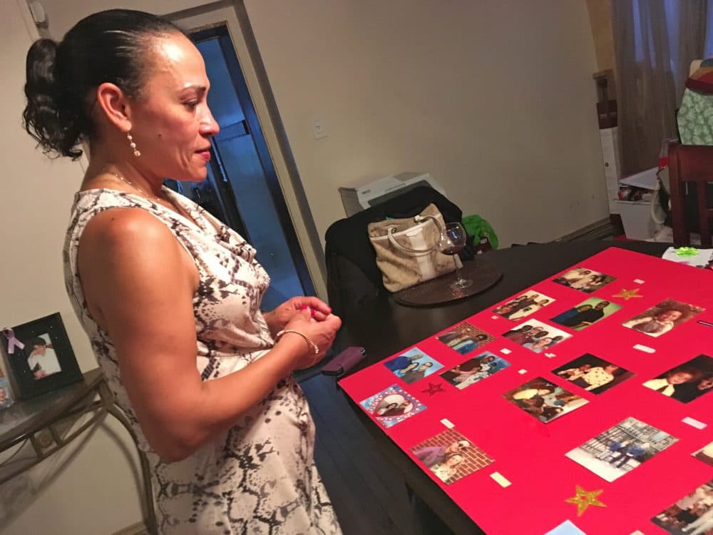Anita Colon looks at photos of her brother Robert and other family members when he was younger. (Sam Fields/Here & Now)